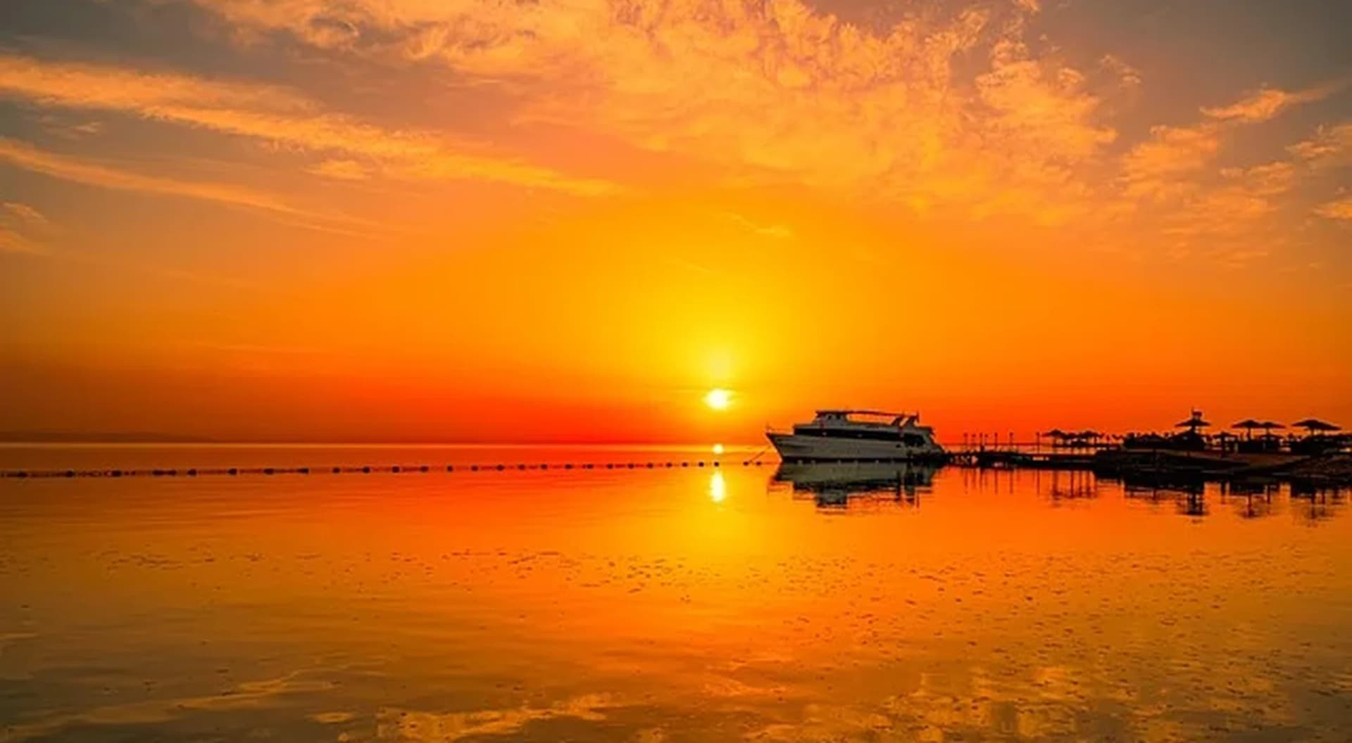 Atardecer sobre el Mar Rojo, con un barco frente a la costa