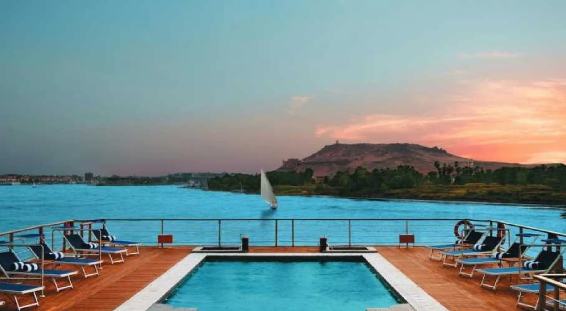 Piscina en la cubierta de un crucero, con el Nilo y una faluca al atardecer