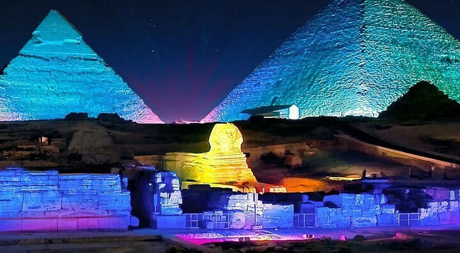 Las pirámides de Guiza y la Esfinge iluminadas con luces de colores durante el espectáculo nocturno